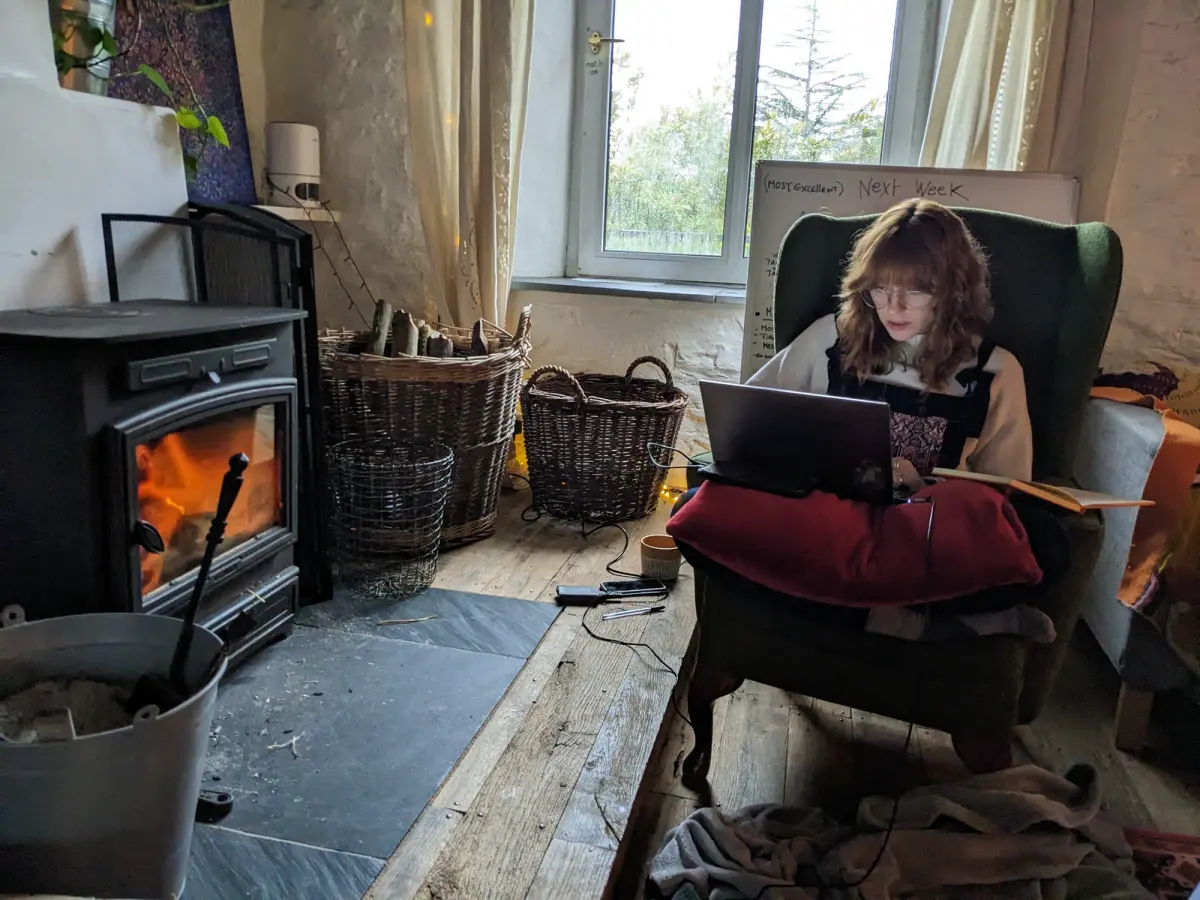 Working on a laptop in an armchair beside the wood burner