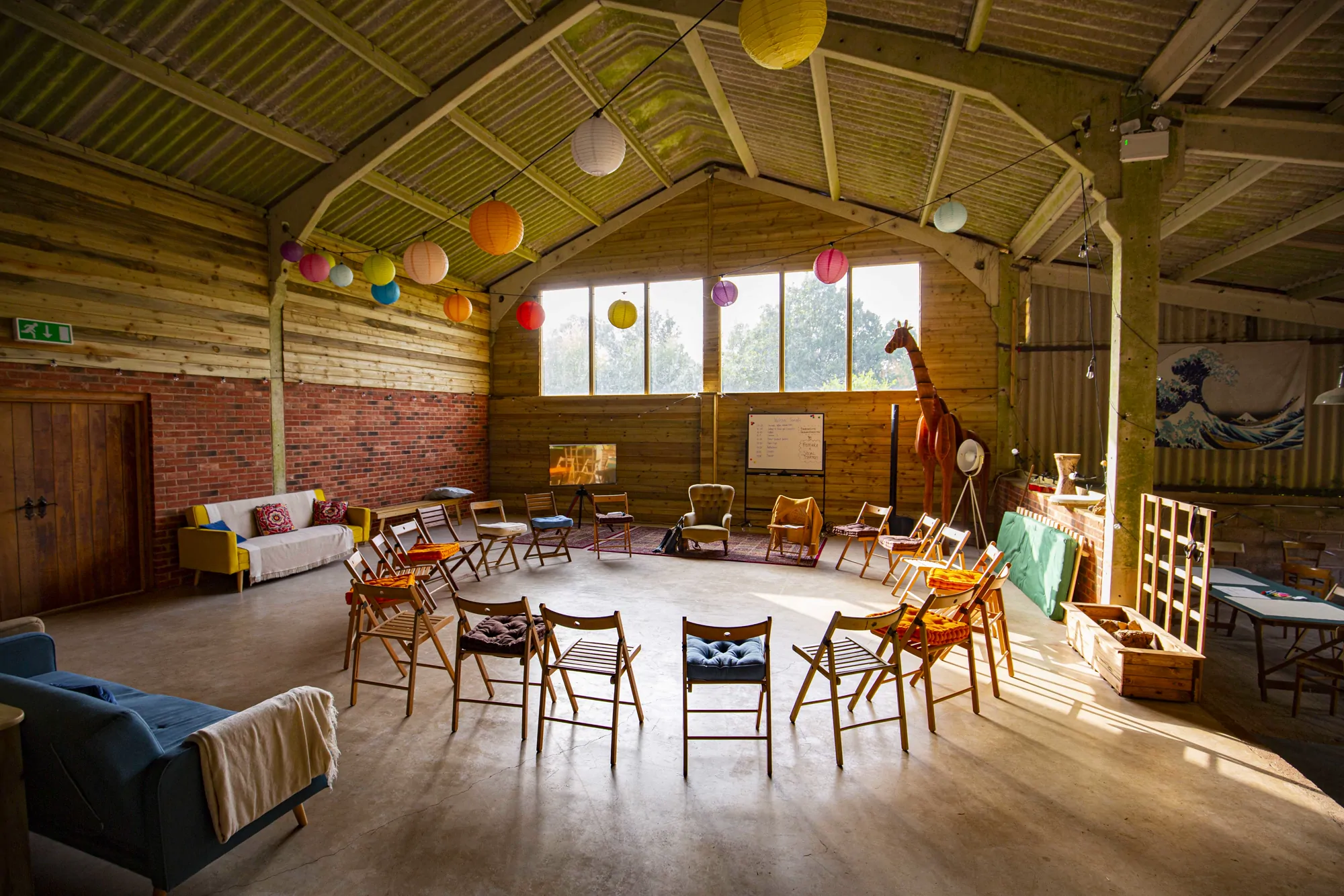 The events barn set with a circle of chairs under paper lanterns