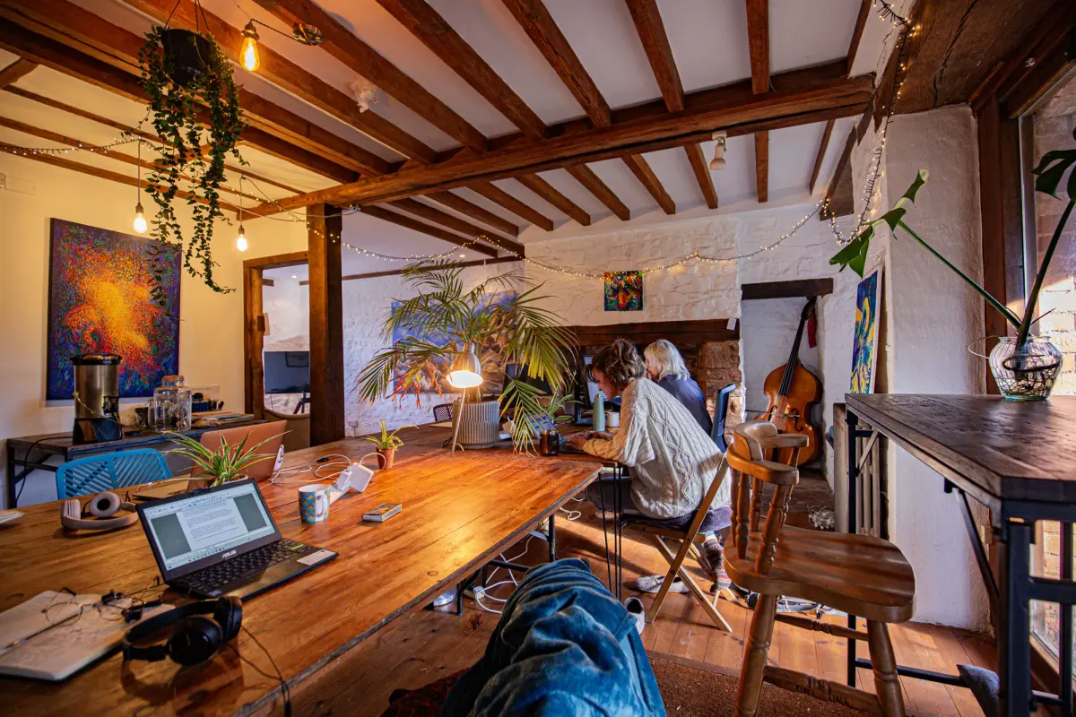 People working together at a table in one of the cosy Mill rooms