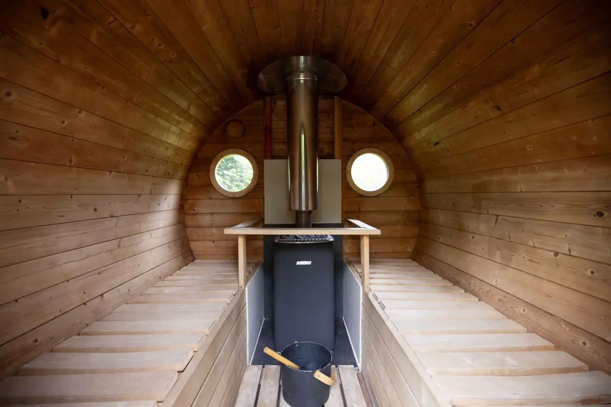 Inside the barrel sauna, benches either side of the stove