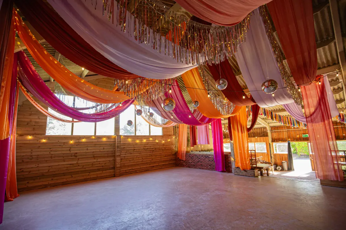 The barn draped in pink and orange silk with mirrorballs