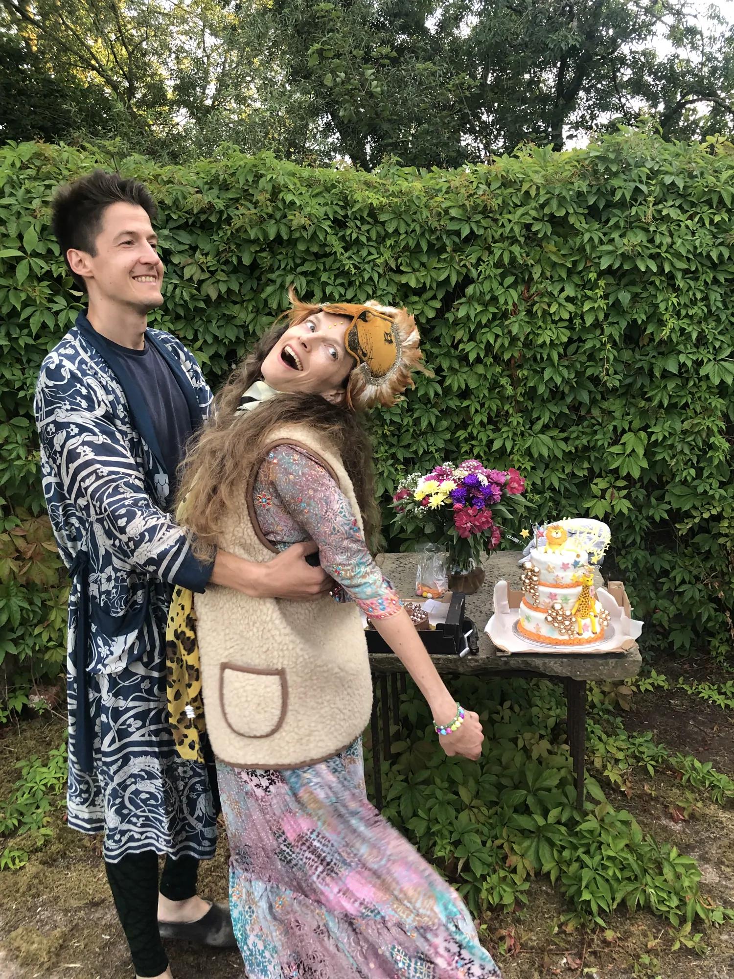 Morgane lifted off her feet beside their wedding cake in the garden